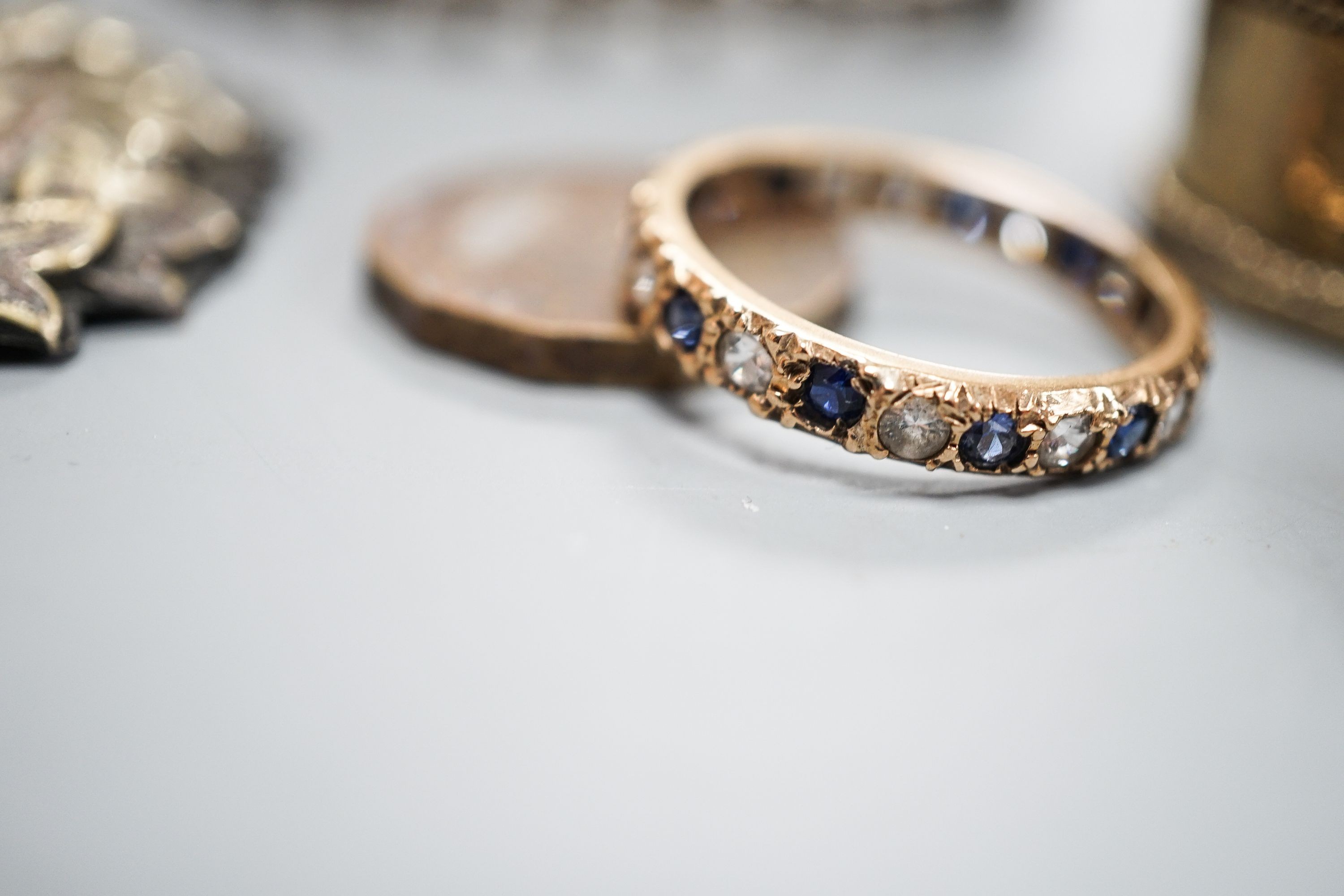 Two white metal bangles including sterling, a marcasite brooch, gem set yellow metal ring and other minor items.